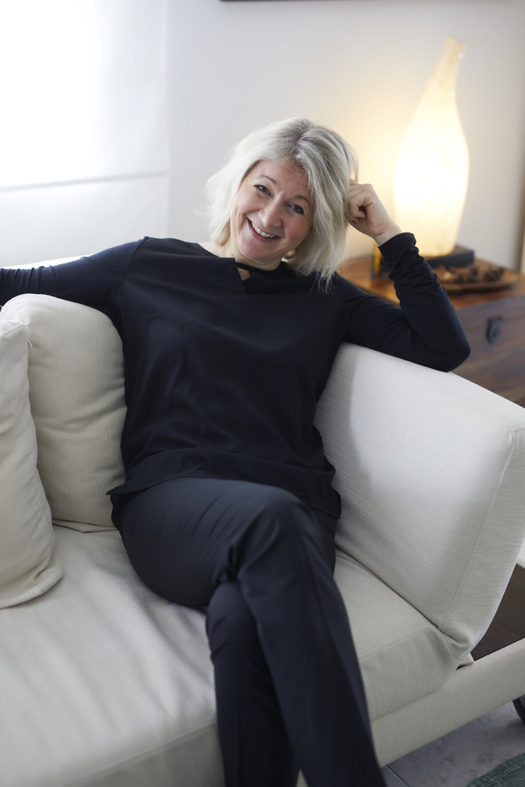 Daria Klisch lachend auf dem Sofa